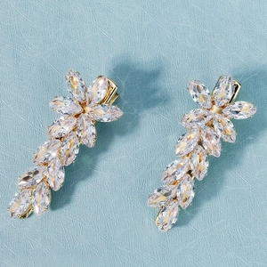 Détail de deux barrettes à cheveux en zircon doré avec des cristaux sur fond bleu
