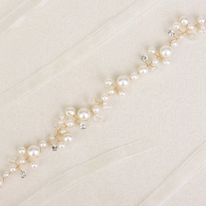 Detail of handmade pearl waist chain with crystals and gold wire for party dresses