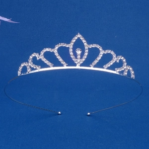 Close-up of silver crown headband with sparkling white rhinestones on blue background