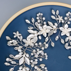 Détail de ceinture de mariée faite main avec fleurs argentées, perles et cristaux