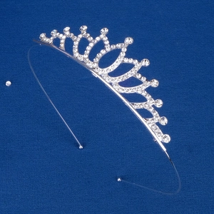 Close-up of silver tiara headband with sparkling rhinestones on dark blue background