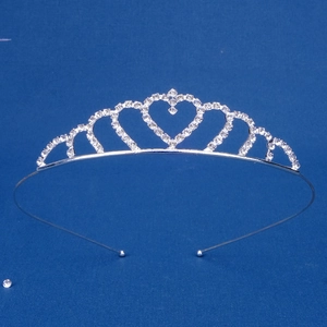 Close-up of heart-shaped princess crown tiara with silver rhinestones on blue background