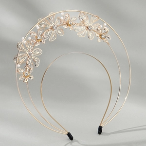 Detail of golden floral crown with hollow flowers, white pearls and sparkling rhinestones