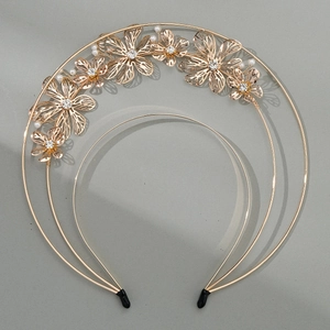 Macro detail of golden flower headband with intricate petals, pearls and clear rhinestones