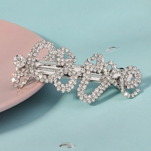 Vue détaillée de la pince à cheveux argentée avec lettrage Love et strass brillants