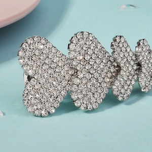 Vue macro de trois cœurs étincelants en strass sur une barrette en alliage argenté