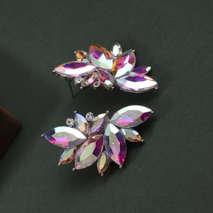Elegant leaf cluster stud earrings with colorful AB crystals on a green background