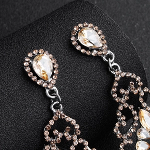 Nahaufnahme von Vintage-Ohrhängern mit Champagner-Kristallen und feinen hohlen Metallarbeiten