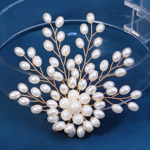 Détail d'une broche florale en perles faite main avec fils dorés sur fond bleu foncé
