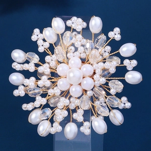 Broche fleur faite main avec perles blanches et cristaux sur fond bleu foncé