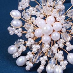 Vue macro d'une broche florale en perles et cristal avec tressage de fil doré