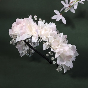 Détail de fleurs en tissu blanc faites à la main et perles de cristal sur le serre-tête