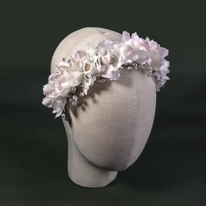 Serre-tête fleuri fait main avec cristaux sur tête de mannequin beige et fond vert