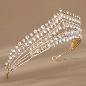 Nahaufnahme eines luxuriösen Gold-Braut-Diadems mit funkelnden Strasssteinen auf braunem Grund