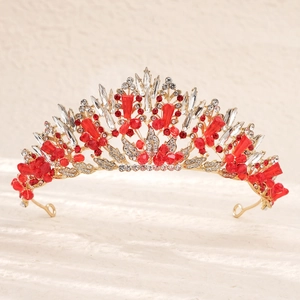 Détails d'une couronne de mariée dorée sertie de cristaux rouges et de strass blancs