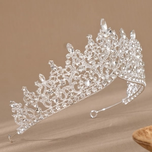 Close-up of a sparkling silver bridal crown with intricate hollow patterns and rhinestones