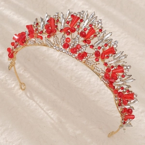 Gros plan sur un diadème de mariée doré avec cristaux rouges et clairs de luxe