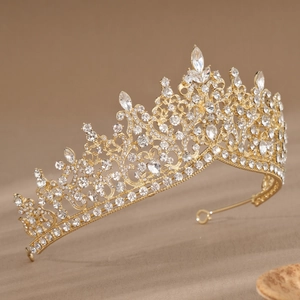 Detail view of a baroque gold bridal crown with white rhinestones and teardrop jewels
