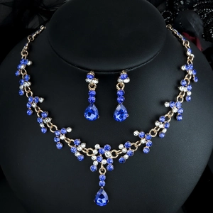 Detailansicht eines luxuriösen Brautschmuck-Sets mit tiefblauen Kristallen und Gold
