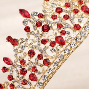 Detail of gold baroque bridal crown with sparkling red teardrop rhinestones and clear gems
