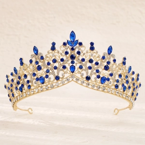 Detailed front view of gold bridal crown with blue teardrop rhinestones and filigree