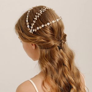 Close-up of handmade bridal headband with white flowers, pearls, and gold wire detail