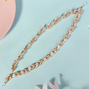 Detailed macro view of golden leaf headband with delicate white flowers and crystal beads