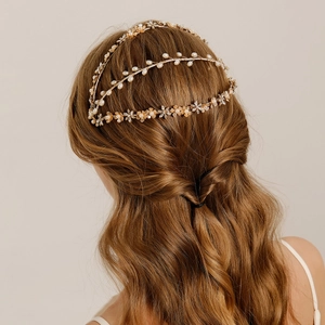 Close-up of golden bridal headband with handmade pearls and floral wreath on a braid