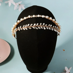 Detail eines doppellagigen Goldblatt-Stirnbands mit weißen Perlen und Kristallen