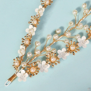Détail d'une vigne de cheveux de mariée faite main avec perles et fleurs laquées