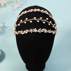 Macro detail of three-layer gold bridal headband with pearls, crystals and leaf designs