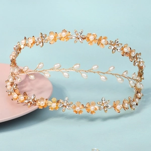 Elegant gold bridal headpiece featuring pearl flowers and sparkling rhinestone clusters