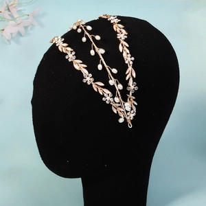 Macro shot of handmade gold floral bridal headband with crystals, pearls and metal leaves