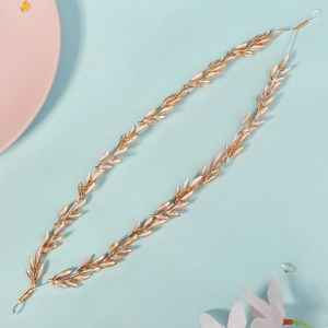 Macro shot of gold leaf wedding headband with intricate metallic texture and leaf vein details