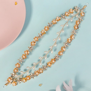 Detailed macro of handmade golden flower hair vine with pearls and sparkling rhinestones