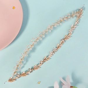 Detail of handcrafted bridal headband with gold wire, crystals and floral rhinestones