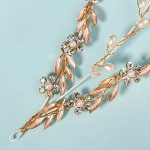 Detailed macro view of bridal hair vine with white leaves, pearls and crystals