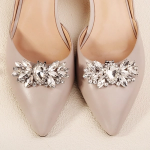 Close-up of sparkling rhinestone flower buckle on light beige pointed toe bridal high heels