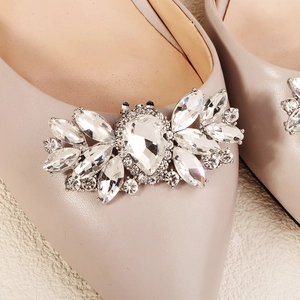 Detailed close-up of crystal bow shoe clip on elegant beige pointed toe high heels