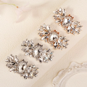 Detailed view of luxury bridal shoe clips with large teardrop crystals and gold finish