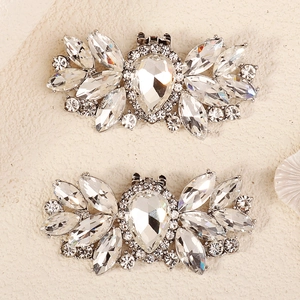 Macro shot of sparkling teardrop crystal shoe clips with intricate rhinestone patterns