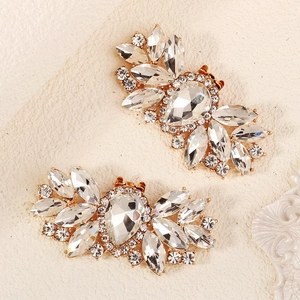 Close-up of sparkling crystal shoe clips with marquise-cut stones and gold metal base