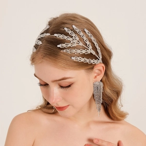 Détail d'un serre-tête de mariée de luxe avec branches en cristal et boucles d'oreilles