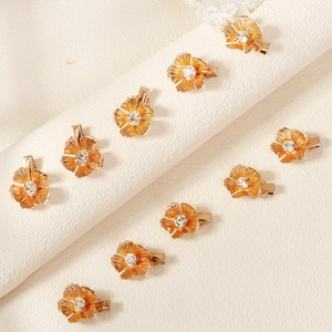 Detailansicht kleiner goldener Blumen-Haarspangen aus Legierung mit Strasssteinen