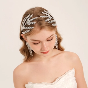 Détail de la coiffe de mariée avec feuilles de cristal et boucles d'oreilles à pampilles