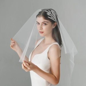 Vue détaillée d'une coiffe en feuilles de cristal argenté avec un long voile de mariée