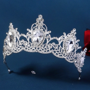 Detailed macro view of baroque silver crown with teardrop rhinestones and floral patterns