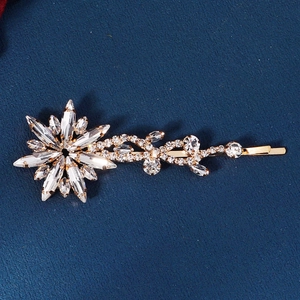 Sparkling star and vine rhinestone hair clip with golden alloy base on blue fabric