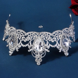 Detail of silver bridal crown with teardrop crystals on a dark textured background