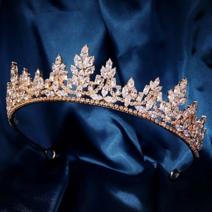 Détail de la couronne de mariée dorée avec zircons brillants sur fond de soie bleue